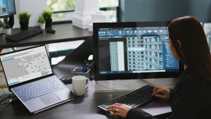 Energy modelling software for architects shown on a laptop running the FREDS building energy analysis dashboard at a design desk