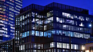 Building energy simulation and occupancy shown by a modern office building at dusk with a scattered pattern of lit and dark floors