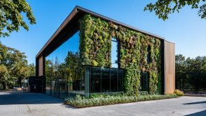 Climate resilience building design: a modern glazed building under intense summer sun and heat haze, upper floors most exposed to overheating